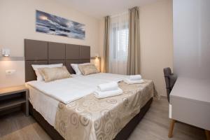 洛维什特Villa Marijola的一间卧室配有一张大床和两条毛巾