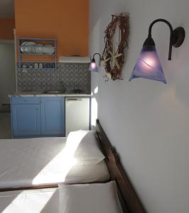加利萨斯Korali apartments的卧室配有一张床和墙上的灯。