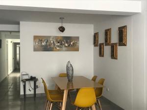 库斯科Cusco Cozy Apartment的一间带桌子和黄色椅子的用餐室