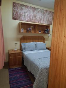 圣洛伦索OKE Apart Hotel的一间卧室配有一张带木制床头板的床