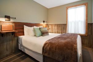 新港玛瑙海滩汽车旅馆的一间卧室设有一张大床和一个窗户。