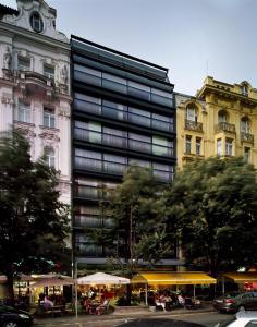 布拉格布拉格大都会酒店的一座高大的建筑,在城市里配有桌子和遮阳伞