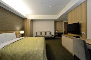 Minxiong嘉义富野渡假酒店的配有一张床和一台平面电视的酒店客房