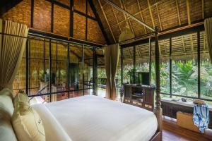 Ban Pa Lau帕拉优果园度假村的一间设有床铺的卧室,位于带窗户的房间内
