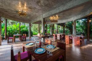 Ban Pa Lau帕拉优果园度假村的一间带桌子和椅子的用餐室