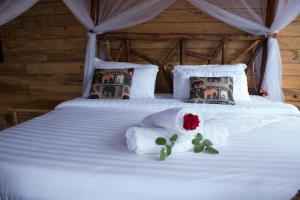 金贾生活水域度假酒店的一张带两个枕头的床,上面有玫瑰