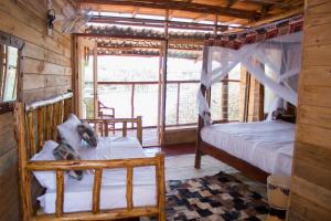 金贾生活水域度假酒店的一间设有两张床的卧室和位于小屋的窗户