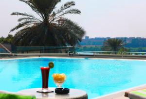 开罗Holiday Inn Cairo Maadi, an IHG Hotel的游泳池配有带饮品的桌子