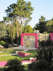 塞拉德洛斯帕德雷斯Hotel Sierra de los Padres的花园中间的粉红色房子