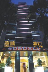 伊兹密尔苏苏卢酒店的前面有 ⁇ 虹灯标志的高楼