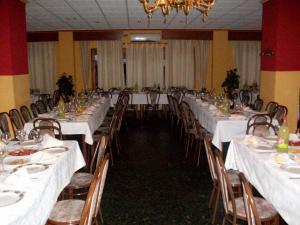 瓜迪克斯穆拉森酒店的宴会厅配有白色的桌椅和吊灯