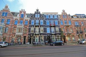 阿姆斯特丹Vondelpark Suite的城市街道上一座带蓝色窗户的大型建筑
