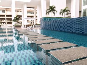 新山Pinnacle Tower Apartment Stay by Feel Suites的蓝色瓷砖建筑中的游泳池