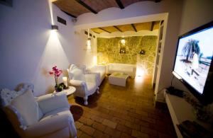 圣马力诺莫达安提卡迪莫拉宾馆的客厅配有白色家具和平面电视