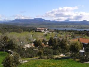 埃尔韦鲁埃科艾尔皮卡楚罗营地旅馆的享有湖泊和山脉的小镇景色。