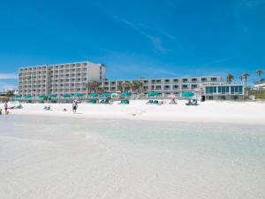 巴拿马城海滩巴拿马市海滩海滨汽车旅馆的一个带遮阳伞的海滩和一个位于酒店后面的酒店