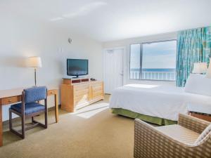 巴拿马城海滩巴拿马市海滩海滨汽车旅馆的一间卧室配有一张床、一张书桌和一台电视