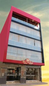 塔克纳Sumaq Hotel Tacna的建筑的侧面有太阳椅标志