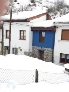 帕哈雷斯La Cuadrina de Anton的雪中带蓝色门的房子