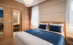 斯普利特VIP Rooms的一间卧室配有一张带蓝色枕头的大床