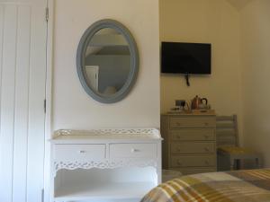 EwennyThe Golden Mile Country Inn的卧室配有镜子和梳妆台