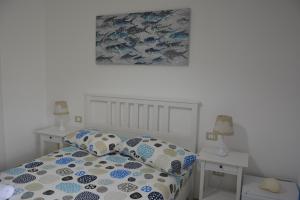 马尔扎梅米"A Livanti" B&B的一间卧室配有一张带蓝色和白色枕头的床
