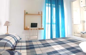 马尔扎梅米"A Livanti" B&B的一间卧室配有一张带蓝色窗帘的床和电视。