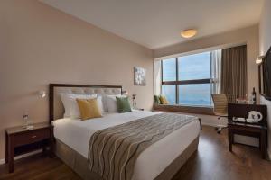 海法Haifa Bay View Hotel By AFI Hotels的一间设有大床和窗户的酒店客房