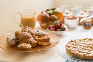 卡斯蒂里昂纳·德拉佩皮迪罗卡农场住宿加早餐旅馆的一张桌子,上面放着一盘糕点和一杯橙汁