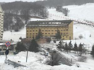 罗卡拉索Villa Aremogna的一条大雪地中的道路旁的一座大建筑