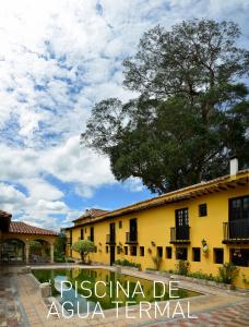 派帕Hotel Hacienda El Salitre的一座黄色的建筑,上面写着“pascua de agua”终点