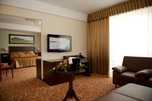 豪伊杜索博斯洛Hotel Atlantis Medical, Wellness & Conference的酒店客房,配有床和电视