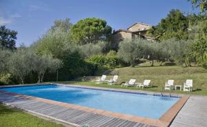 科洛迪Villa La Loggia的一个带椅子的庭院和房子的游泳池