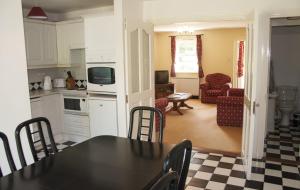 奥赫里姆Riverside Holiday Homes的厨房以及带桌椅的起居室。