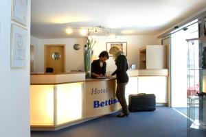 金茨堡Hotel Bettina garni的两名妇女站在酒店的浴室柜台