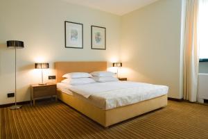 萨格勒布拉古纳泽格布酒店的一间卧室配有一张大床和两盏灯