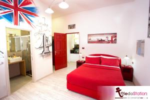 那不勒斯拖乐都站B＆B酒店的一间带红色床的卧室和一间浴室