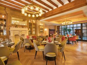 马略卡岛帕尔马格罗利亚德桑特约姆酒店的一间带桌椅和壁炉的餐厅