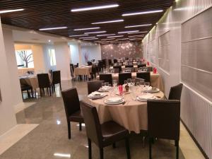阿维拉圣安东尼奥酒店的大型用餐室配有长桌和椅子
