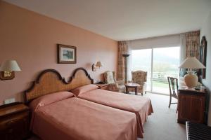 奥洛特里夫鲁威亚酒店的一间卧室配有一张床、一张书桌和一个窗户。