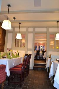吕讷堡Hotel Zum Roten Tore的用餐室配有桌椅和灯光