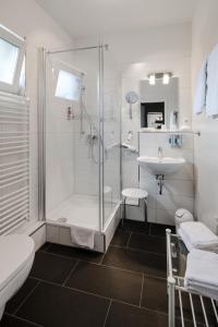 吕讷堡Hotel Zum Roten Tore的带淋浴和盥洗盆的浴室