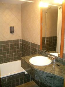 坎普罗东圣洛克酒店的浴室配有盥洗盆、镜子和浴缸