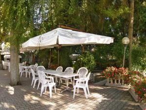 卡瓦利诺洛坎达达斯卡帕宾馆的白色遮阳伞下的白色桌子和椅子