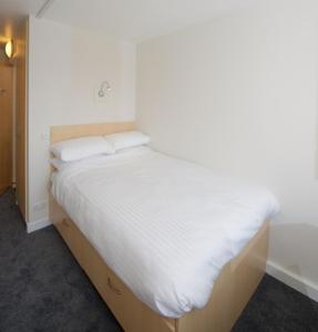 科克University Hall Apartments - UCC Summer Beds的一张带白色床单和枕头的床