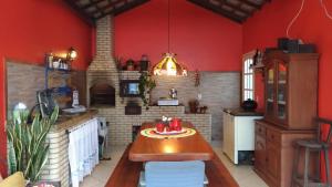 卡波布里奥Casa na Praia do Foguete的一间厨房,里面设有红色的墙壁和一张桌子