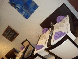Puy-lʼÉvêqueHôtel restaurant HENRY的一张桌子,上面放有酒杯和紫色餐巾
