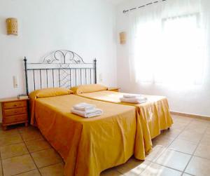 莫莱拉Apartments Benimeit的一间卧室配有两张带黄床单的床