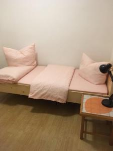 Düngenheim丁根海姆度假屋LandhausDüngenheim的一张带粉红色床单和枕头的床