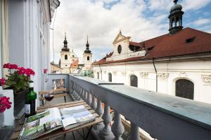布拉格皇家路住所酒店的大楼的阳台,配有带一瓶葡萄酒的桌子